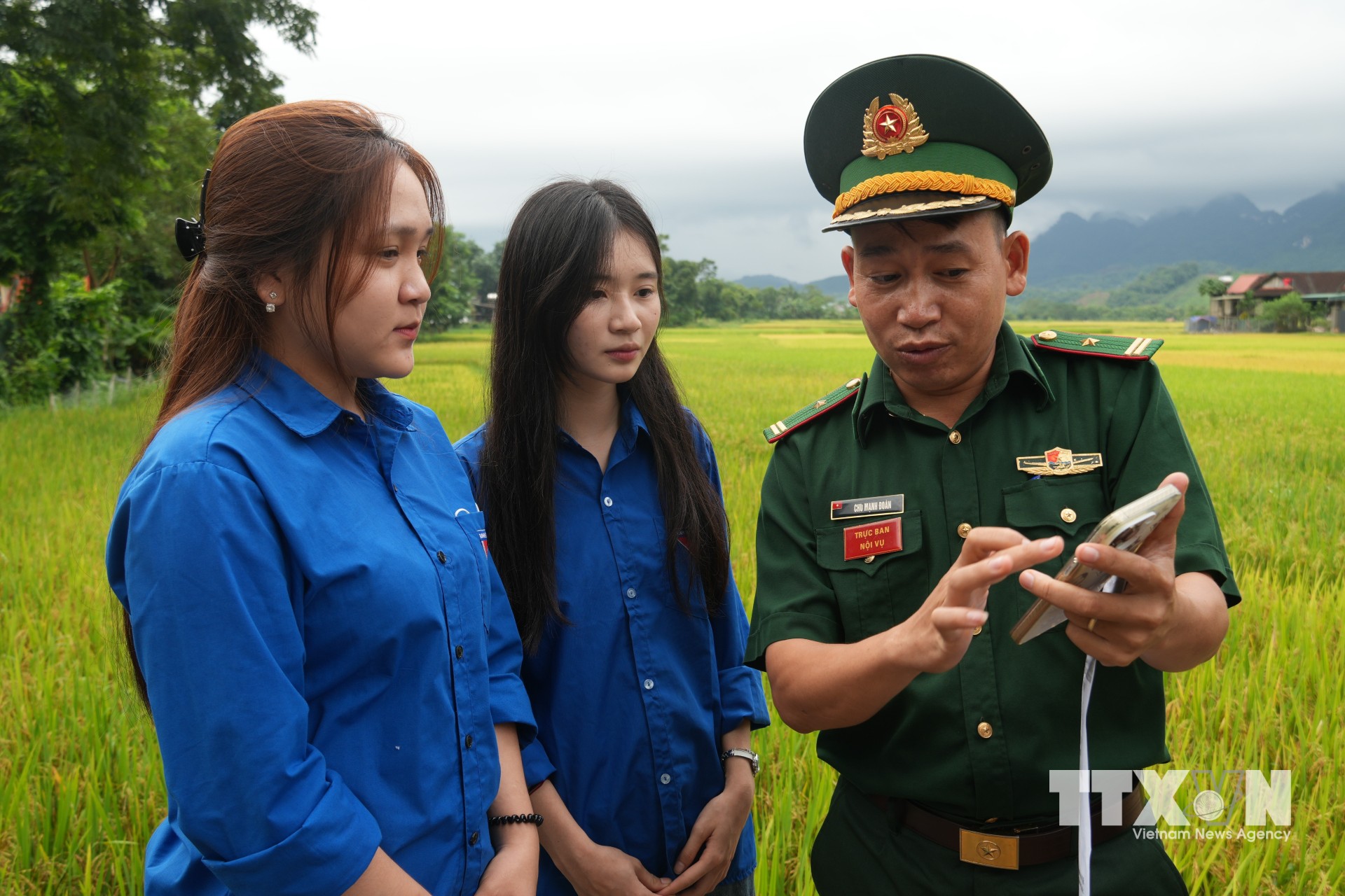 Chiến sĩ Đồn biên phòng Môn Sơn, xã Môn Sơn hướng dẫn đoàn viên thanh niên quét mã QR "Hòm thư điện tử ẩn danh" để tố giác tội phạm. (Ảnh: Bích Huệ/TTXVN)